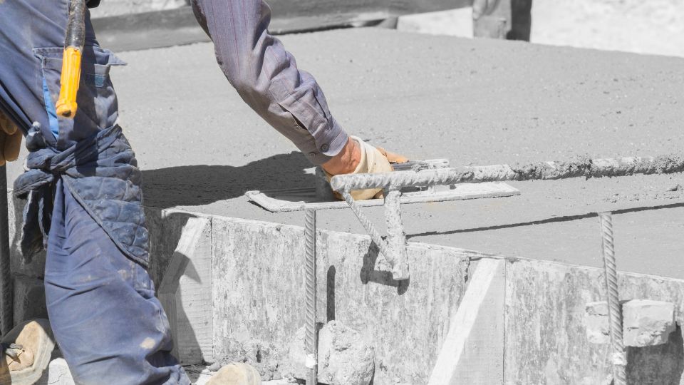 Concrete contractor levelling off a new concrete base