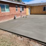 A concrete patio in front of a house made with stamped concrete.