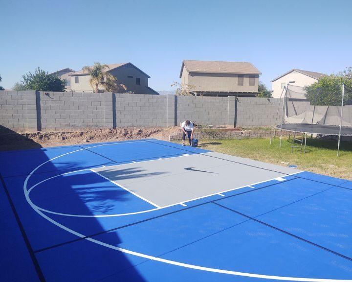 Scottsdale Concrete Solutions is installing a basketball court in a backyard on a concrete surface.