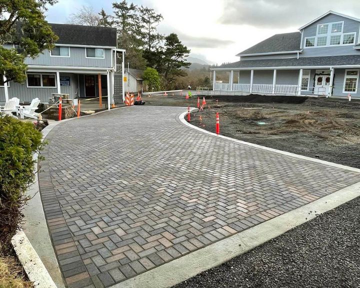 A driveway with brick pavers in front of a house.