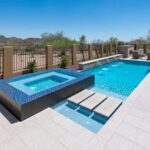 A backyard swimming pool with a hot tub designed and built by Scottsdale Concrete Solutions, expert concrete contractors.