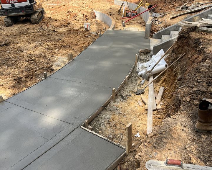 Concrete contractors are building a concrete walkway on a construction site.